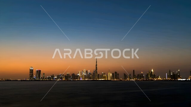 الفن الهندسي المعماري للمنشآت التجارية والسكنية، أماكن ومعالم سياحية مشهورة، منظر ناطحات السحاب والأبراج في مدينة دبي وقت غروب الشمس، النمو والتقدم العمراني للمباني والمنتجعات الفاخرة المطلة على البحر في الإمارات العربية المتحدة