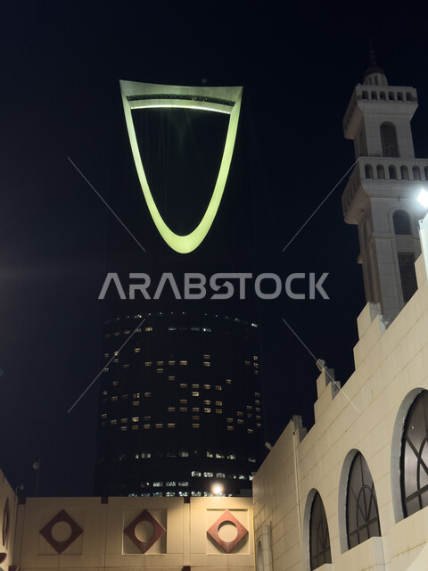 الفن الهندسي المعماري المتطور لمبنى برج المملكة المضاء في  العاصمة السعوديه, تنمية المنشآت الهندسية الحديثة في المملكة، أماكن ومعالم سياحية مشهورة لجذب الزوار من شتى أنحاء العالم، ناطحات السحاب والمباني السكنية في وقت الليل في مدينة الرياض