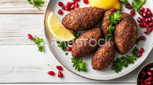 طبق من الكبة المقلية مع حبات الرمان وقطع الليمون، وجبة ذات قيمة غذائية عالية، فنون التقديم في مطاعم ومطابخ المملكة العربية السعودية، أطباق من المأكولات العربية التقليدية الشعبية، وصفات طعام شهية صحية ولذيذة