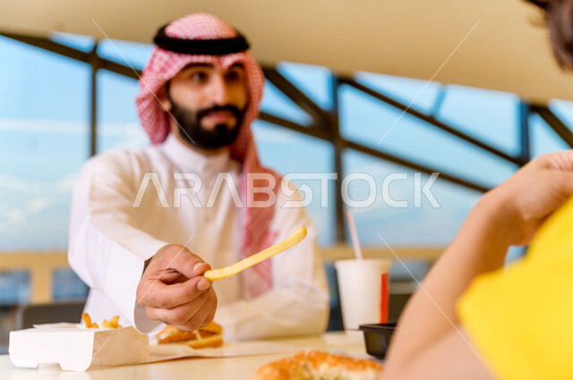 صورة لمائدة طعام خاصة برجل سعودي خليجي ، يقضي اجواء رائعة  في المطعم ، وجبات سريعة ، تناول الطعام في ردهة المطاعم في المركز التجاري .