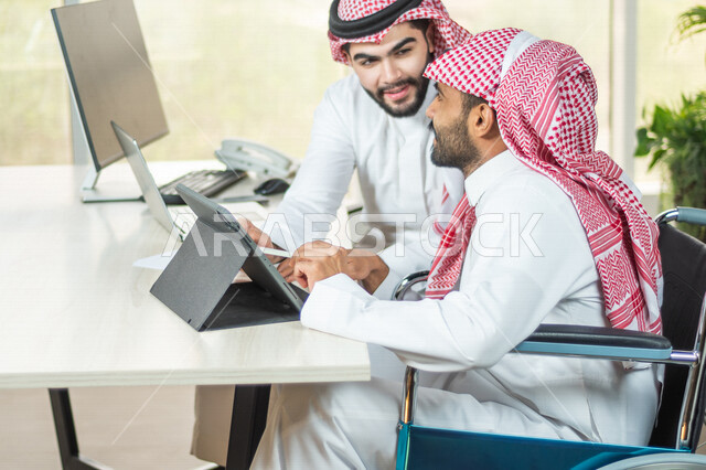 موظف عربي سعودي خليجي من ذوي الهمم يعمل على جهاز التابلت في مقر العمل, دمج و توظيف ذوي الاعاقه في مختلف المجالات, التمكين الاجتماعي, اهتمام  ودعم المجتمع السعودي لذوي الاحتياجات الخاصه, شعور ذوي الهمم بالراحه والطمأنينه في بيئتهم