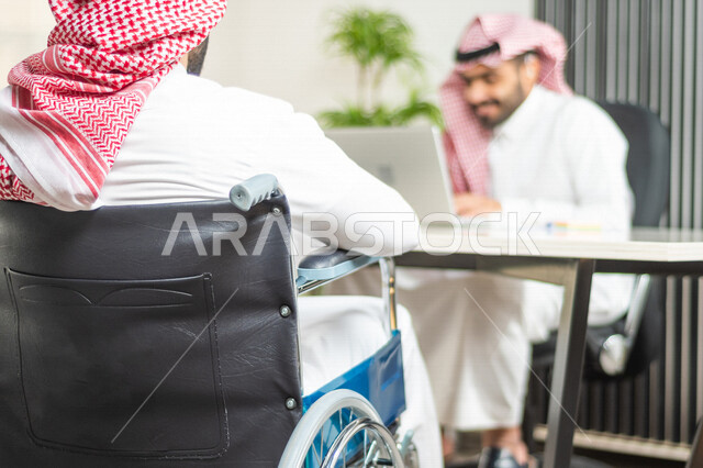 موظف عربي سعودي خليجي من ذوي الهمم يعمل على جهاز الحاسوب في مقر العمل, دمج و توظيف ذوي الاعاقه في مختلف المجالات, التمكين الاجتماعي, اهتمام  ودعم المجتمع السعودي لذوي الاحتياجات الخاصه, شعور ذوي الهمم بالراحه والطمأنينه في بيئتهم