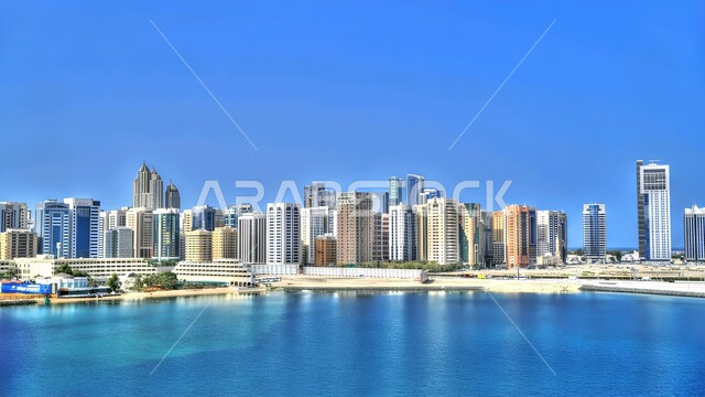 Modern architectural arts and designs, building a developed civilized future, high-rise commercial buildings and facilities, improving and developing infrastructure, Dubai's coastal tourist facade, urban progress and growth in the United Arab Emirates, towers and skyscrapers overlooking the sea