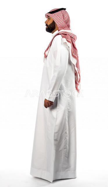 بورتريه لرجل عربي سعودي خليجي يقوم بجلسة تصوير بإيماءات وجه ويدين مختلفة ، منظر جانبي لرجل سعودي مسلم يرتدي زي تقليدي سعودي مع شماغ وعقال ، خلفية بيضاء