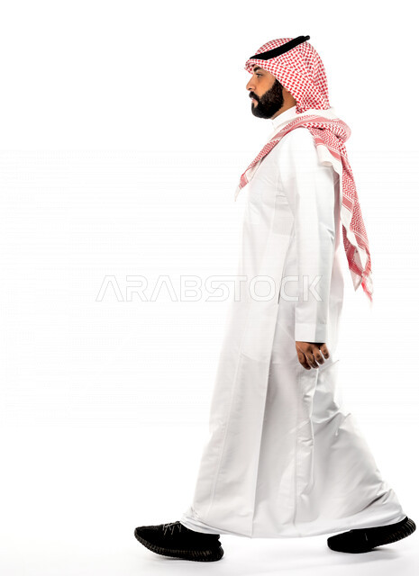 بورتريه لرجل عربي سعودي خليجي يقوم بجلسة تصوير بإيماءات وجه ويدين مختلفة ، منظر جانبي لرجل سعودي مسلم يرتدي زي تقليدي سعودي مع شماغ وعقال ، خلفية بيضاء
