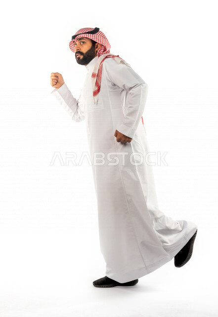 بورتريه لرجل عربي سعودي خليجي يقوم بجلسة تصوير بإيماءات وجه ويدين مختلفة ، منظر جانبي لرجل سعودي مسلم يرتدي زي تقليدي سعودي مع شماغ وعقال ، خلفية بيضاء