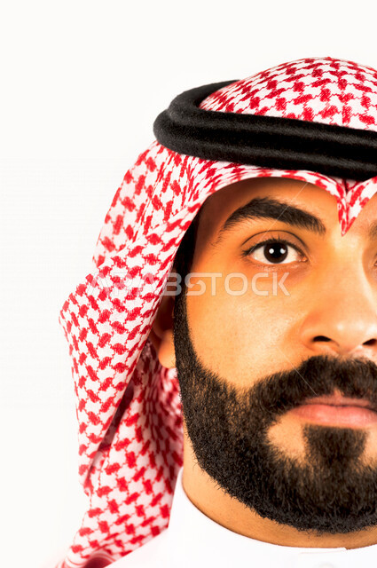 بورتريه بصورة مقربة لرجل سعودي خليجي يقوم بجلسة تصوير ، ينظر لأعلى ، خلفية بيضاء لرجل سعودي مسلم يرتدي الزي التقليدي السعودي مع شماغ وعقال