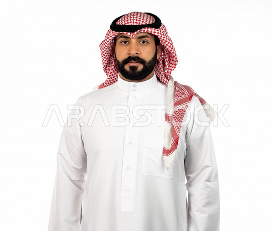بورتريه لرجل سعودي خليجي يقوم بجلسة تصوير، ينظر إلى الكاميرا بإيماءات وجه ويدين مختلفة ، خلفية بيضاء لرجل سعودي مسلم يرتدي زي تقليدي سعودي مع شماغ وعقال