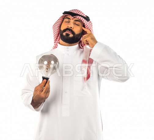 بورتريه لرجل سعودي خليجي عبقري يحمل المصباح الضوئي بإيماءات وجه ويدين مختلفة ، أفكار إبداعية تطويرية ، مفهوم الفكرة مع الإبتكار والإلهام ، تحقيق الإنجازات والإبتكارات ، براءة الإختراع ، خلفية بيضاء ، المصباح الكهربائي الضوئي