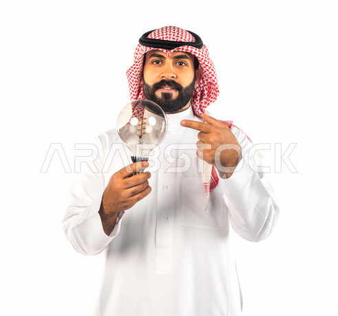 بورتريه لرجل سعودي خليجي عبقري يحمل المصباح الضوئي بإيماءات وجه ويدين مختلفة ، أفكار إبداعية تطويرية ، مفهوم الفكرة مع الإبتكار والإلهام ، تحقيق الإنجازات والإبتكارات ، براءة الإختراع ، خلفية بيضاء ، المصباح الكهربائي الضوئي