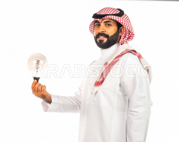 بورتريه لرجل سعودي خليجي عبقري يحمل المصباح الضوئي بإيماءات وجه ويدين مختلفة ، أفكار إبداعية تطويرية ، مفهوم الفكرة مع الإبتكار والإلهام ، تحقيق الإنجازات والإبتكارات ، براءة الإختراع ، خلفية بيضاء ، المصباح الكهربائي الضوئي