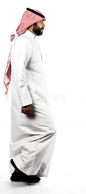 بورتريه لرجل عربي سعودي خليجي يقوم بجلسة تصوير بإيماءات وجه ويدين مختلفة ، منظر جانبي لرجل سعودي مسلم يرتدي زي تقليدي سعودي مع شماغ وعقال ، خلفية بيضاء