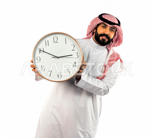 بورتريه لرجل سعودي خليجي يحمل ساعة رقمية كبيرة بإيماءات وجه ويدين مختلفة ، خلفية بيضاء لرجل سعودي يرتدي الزي التقليدي السعودي مع شماغ وعقال ، مفهوم العد التنازلي ، الدقة في المواعيد ، التذكيرات والتنبيهات الثابته ، مواعيد العمل ، إنجاز المهامات في الوقت