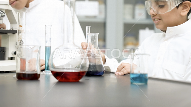تلميذ عربي خليجي سعودي، استخدام الانابيب في اجراء التجارب العلمية داخل المختبر الكيميائي المدرسي، الفصل الدراسي للعلوم، بحوث علمية، التعليم في المملكة العربية السعودية