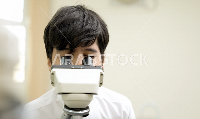 تلميذ عربي خليجي سعودي يرتدي الزي المدرسي، اجراء البحوثات والاختبارات باستخدم التلسكوب داخل مختبر المدرسة، بحوث علمية، التعليم في المملكة العربية السعودية