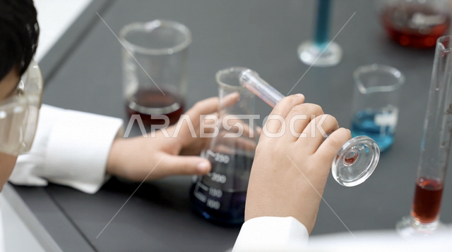 تلميذ عربي خليجي سعودي، استخدام الانابيب في اجراء التجارب العلمية داخل المختبر الكيميائي المدرسي، الفصل الدراسي للعلوم، بحوث علمية، التعليم في المملكة العربية السعودية