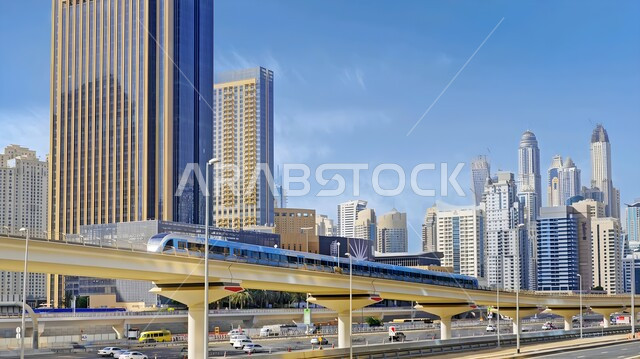 توفير التسهيلات والخدمات للمغادرين والقادمين، مفهوم المواصلات العامة، أحدث أنظمة السكك الحديدية، الاهتمام بالبنية التحتية للجسور والطرقات، محطات وصول المسافرين، مترو دبي يعبر فوق جسر في الإمارات العربية المتحدة، الفن الهندسي المعماري للأبراج وناطحات السحاب