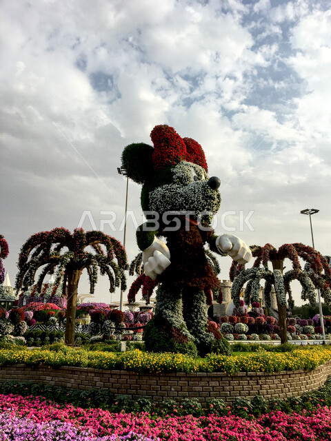 صورة لتمثال عملاق على شكل ميكي ماوس مصنوع من الورد في حديقة دبي المعجزة في الإمارات العربية المتحدة، معالم دبي السياحية، جمال حدائق دبي، السياحة في الإمارات