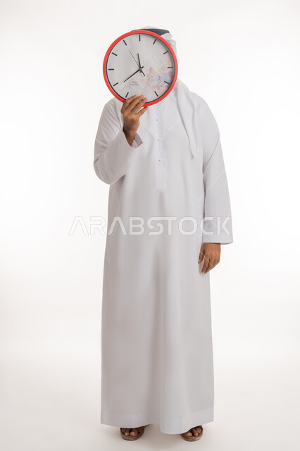 التنبيهات والتذكيرات الثابته، الدقة في المواعيد, بورتريه  لرجل عربي خليجي إماراتي يرتدي الكندورة والغترة يقف باستعداد واستقامة يضع ساعة رقمية كبيرة على وجهه، انجاز المهامات في الوقت، الجسم بالطول الكامل, خلفية بيضاء