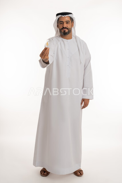 Achievements and innovations, portrait of an Arab Gulf Emirati man wearing a kandura and a ghutra holding a light bulb, looking at the camera with expressions of pride, joy and self-confidence, concept of idea with innovation and inspiration, creative development ideas, full body length, white background