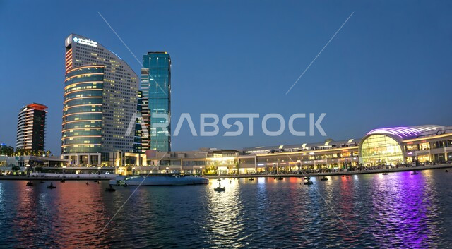 Artistic urban development of towers and skyscrapers in the United Arab Emirates, modern architectural art of hotels and resorts, famous tourist attractions and landmarks, Crowne Plaza Hotel in Dubai on the waterfront illuminated at night