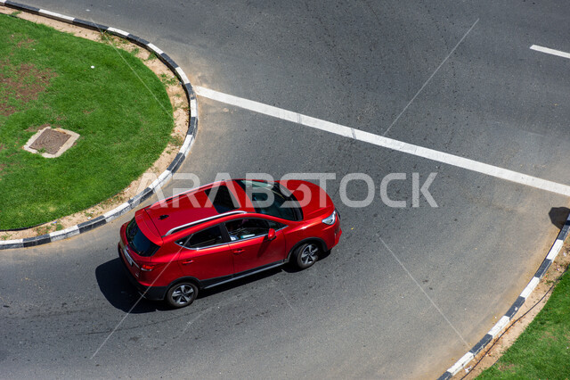 حركة مرور السيارات في الطرقات، فعاليات ومعارض متميزة، صورة من الاعلى لسيارة حمراء  تسير في احدى شوارع مدينة دبي، التجهيزات الطرقية العامة في الامارات العربية المتحدة