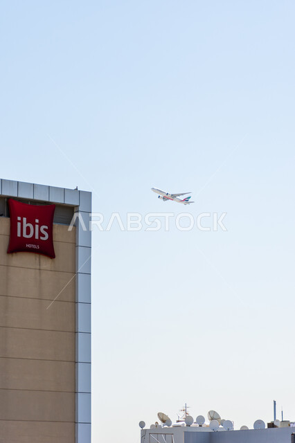 Providing advanced services for easy movement between countries, an Emirates fleet aircraft flying in the sky during the day, means of transportation and air transportation, leading airlines and companies in the Middle East