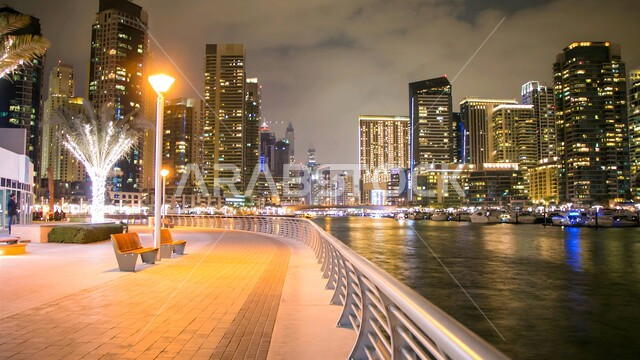 الفن الهندسي المعماري لبناء الابراج وناطحات السحاب المضيئة ليلا على الطراز الحديث المتطور، النمو والتقدم العمراني في الامارات العربية المتحدة، النقل البحري على مرسى دبي، ميناء ومرفأ يخوت فاخرة، الواجهة البحرية في الخليج العربي، أماكن سياحية لجذب السياح، كورنيش القناة في الليل