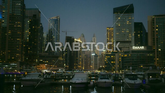 الفن الهندسي العماري للأبراج وناطحات السحاب في دولة الإمارات العربية المتحدة، النقل البحري في مرسى دبي، الفن المعماري المتطور للمرافق التجارية والسكنية، ميناء اليخوت الفاخر مارينا مول في وقت المساء، المعالم السياحية المشهورة