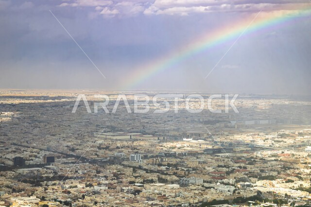 منظر قوس القزح بعد هطول الأمطار في الرياض، الطرقات والشوارع الإسفلتية المعبدة، النمو والتقدم العمراني للمنشآت والمباني السكنية والتجارية في المملكة العربية السعودية