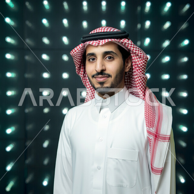 مفهوم الأناقة والرجولة، التقاط صور شخصية للوثائق الرسمية، صورة مقربة لشاب عربي خليجي سعودي يرتدي الشماغ والثوب التقليدي ينظر إلى الكاميرا بإيماءات الثقة بالنفس، الاعتناء والاهتمام بالمظهر الخارجي
