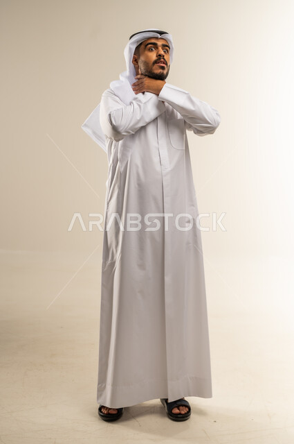 الاحساس بألم البلعوم, الحاجة إلى العلاج والدواء, مفهوم الاهتمام بالصحة, الاصابة بنزلة برد والتهاب الحلق, بورتريه لرجل عربي خليجي كويتي يرتدي الثوب التقليدي ويضع يديه على حلقه ويشعر بالاختناق, صورة الجسم بالطول الكامل، خلفية بيضاء
