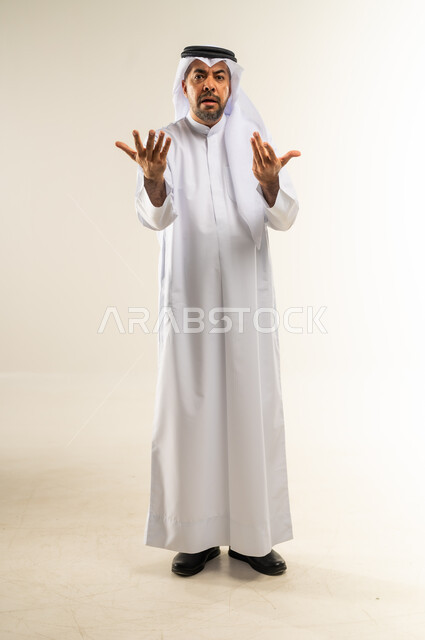 الإستفهام حول موضوع معين, بورتريه  لرجل عربي خليجي كويتي يرتدي الثوب والغترة يرفع يديه نحو الأعلى بإيماءات عدم المعرفة, التساؤل والإستغراب والاستفسار عن أمر ما، الغموض وعدم الوضوح، خلفية بيضاء