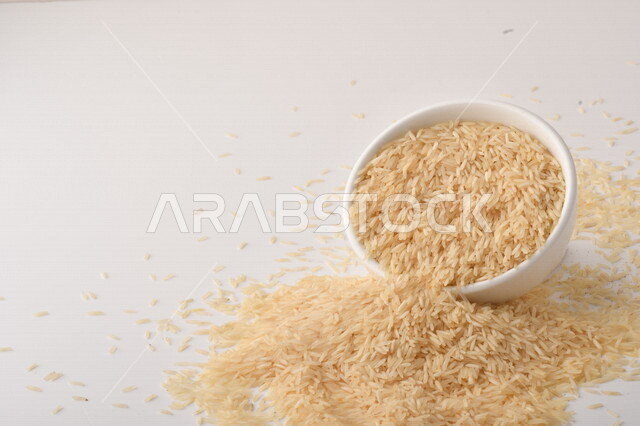 بورتريه لطبق ابيض مليئ بحبيبات الارز, محصول الارز الزراعي, ارز ابيض غير مطبوخ, أرز ابيض منثور على الأرض, محاصيل زراعيه