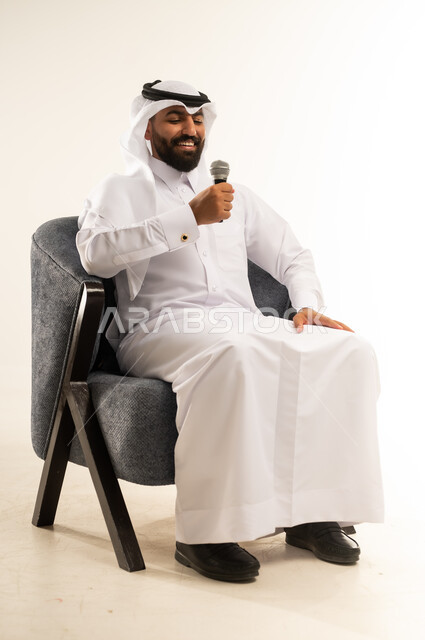 ايماءات الاستمتاع والتفاعل والاندماج، إقامة الندوات وورش العمل والتحاور والنقاش مع الآخرين، تسجيل المقاطع الصوتية والغنائية، بورتريه لرجل عربي خليجي قطري مبتسم يرتدي الثوب التقليدي والغترة يجلس على كرسي مريح يقوم بالقاء الخطابات والكلمات باستخدام مكبر الصوت ، خلفية بيضاء
