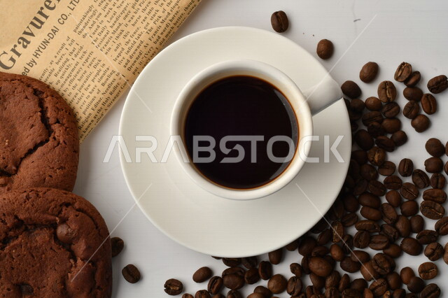 فنجان قهوه سوداء مع قطع الكوكيز اللذيذه,  قهوة اسبرسو داكنه, رقائق البسكويت بالشوكولاته, حبوب البن المتناثره