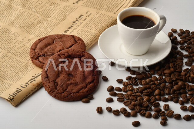 فنجان قهوه سوداء مع قطع الكوكيز اللذيذه,  قهوة اسبرسو داكنه, رقائق البسكويت بالشوكولاته, حبوب البن المتناثره