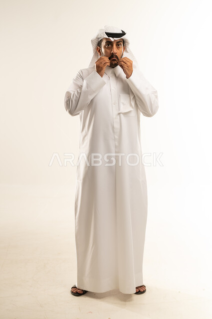 الفشل في تحقيق أمر ما, الانزعاج بسماع الأخبار السيئة، بورتريه لرجل عربي خليجي قطري يرتدي الغترة والثوب التقليدي ينظر إلى الكاميرا بإيماءات الحزن والوقوف باستقامة, الشعور بالخذلان والندم، صورة الجسم بالطول الكامل، خلفية بيضاء