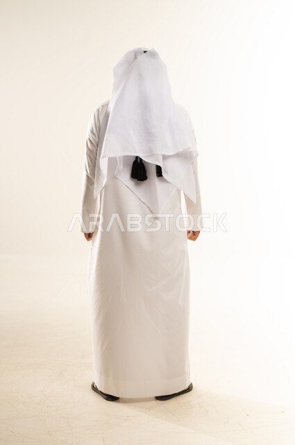 الاهتمام بالمظهر الخارجي, مفهوم الأناقة والرجولة, بورتريه من الخلف لرجل عربي خليجي قطري يرتدي الثوب التقليدي والغترة يقف باستقامة واعتدال, الجسم بالطول الكامل, خلفية بيضاء