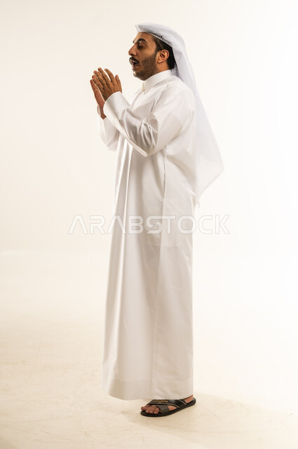 التهاب الأنف التحسسي, الشعور بالمرض و الزكام والحاجة الى العلاج والدواء, بورتريه لشاب عربي خليجي قطري يرتدي الثوب التقليدي والغترة يضع يديه على وجهه بإيماءات العطاس, صوة الجسم بالطول الكامل، خلفية بيضاء