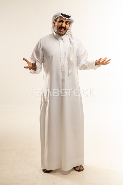 عدم التاكد والقدرة على اتخاذ القرار، التردد بشأن أمر معين، بورتريه لرجل عربي خليجي قطري يرتدي الثوب التقليدي والغترة يرفع كفيه نحو الأعلى بتعابير الحيرة، النظر إلى الكاميرا بإيماءات الاستغراب، صورة الجسم بالطول الكامل، خلفية بيضاء