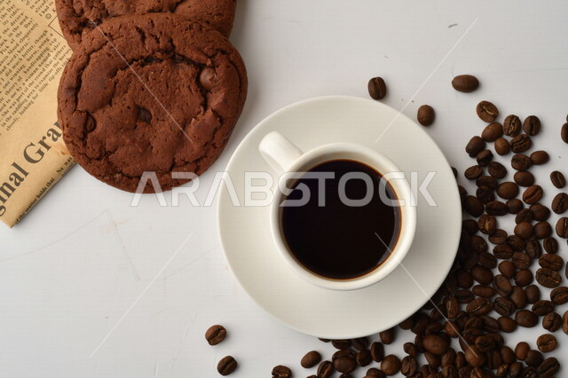 فنجان قهوه سوداء مع قطع الكوكيز اللذيذه,  قهوة اسبرسو داكنه, رقائق البسكويت بالشوكولاته, حبوب البن المتناثره
