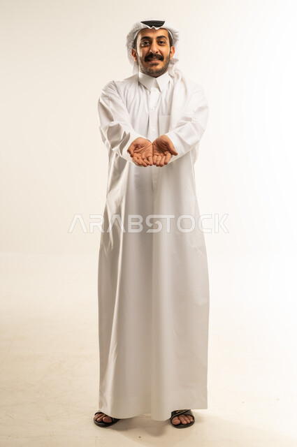 Hand gesture indicating a request for help and assistance, palms extended forward as a sign of need, portrait of a Qatari Gulf Arab man wearing traditional thobe and ghutra standing with gestures of helplessness and supplication, full body image, white background