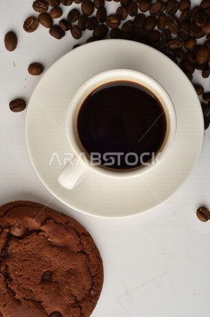 فنجان قهوه سوداء مع قطع الكوكيز اللذيذه,  قهوة اسبرسو داكنه, رقائق البسكويت بالشوكولاته, حبوب البن المتناثره