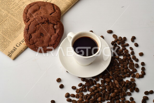 فنجان قهوه سوداء مع قطع الكوكيز اللذيذه,  قهوة اسبرسو داكنه, رقائق البسكويت بالشوكولاته, حبوب البن المتناثره