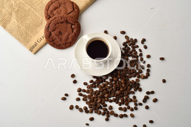 فنجان قهوه سوداء مع قطع الكوكيز اللذيذه,  قهوة اسبرسو داكنه, رقائق البسكويت بالشوكولاته, حبوب البن المتناثره