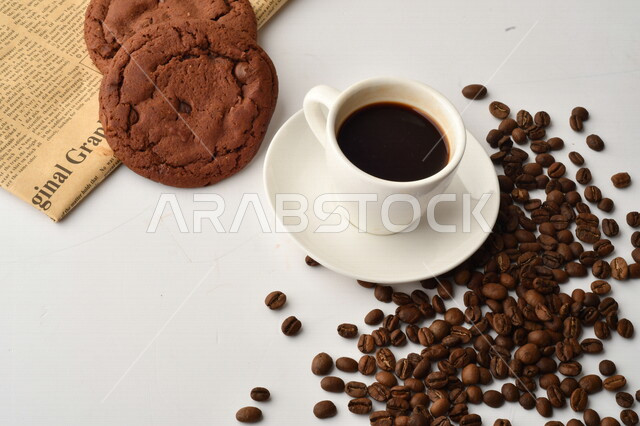 فنجان قهوه سوداء مع قطع الكوكيز اللذيذه,  قهوة اسبرسو داكنه, رقائق البسكويت بالشوكولاته, حبوب البن المتناثره
