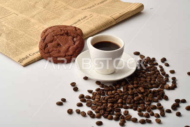 فنجان قهوه سوداء مع قطع الكوكيز اللذيذه,  قهوة اسبرسو داكنه, رقائق البسكويت بالشوكولاته, حبوب البن المتناثره