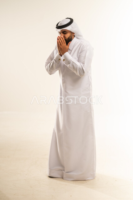 التهاب الأنف التحسسي, الشعور بالمرض و الزكام والحاجة الى العلاج والدواء, بورتريه لشاب عربي خليجي قطري يرتدي الثوب التقليدي والغترة يضع يديه على وجهه بإيماءات العطاس, صوة الجسم بالطول الكامل، خلفية بيضاء