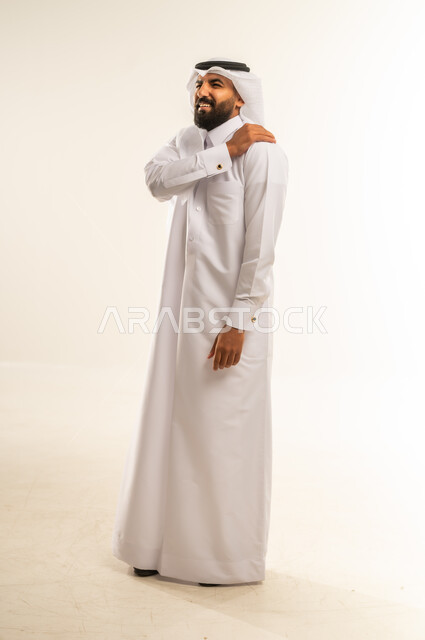 التهاب العضلات والمفاصل، الإحساس بالتعب والإرهاق, إيماءات الألم في الأكتاف، بورتريه لرجل عربي خليجي قطري يرتدي الثوب و الغترة يضع يده على كتفه بتعابير الوجع، الحاجه لوضع خطة علاجية, طلب المساعده للذهاب الى المستشفى، صورة الجسم بالطول الكامل، خلفية بيضاء